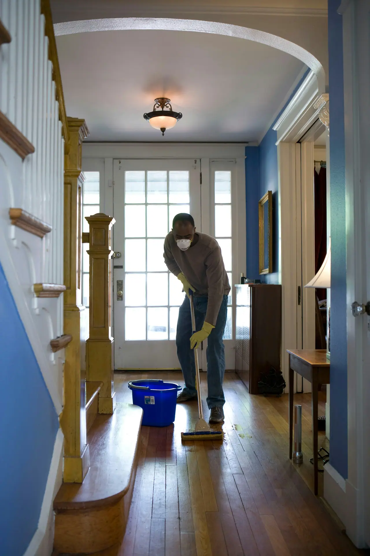 Cleaner mopping the entry of a family home