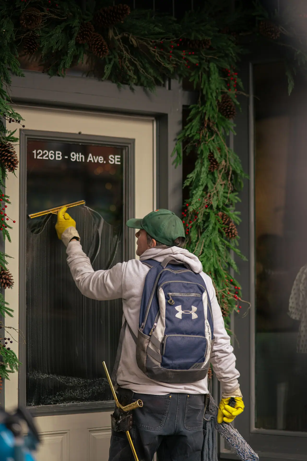 Cleaner squeegeeing a shopfront window