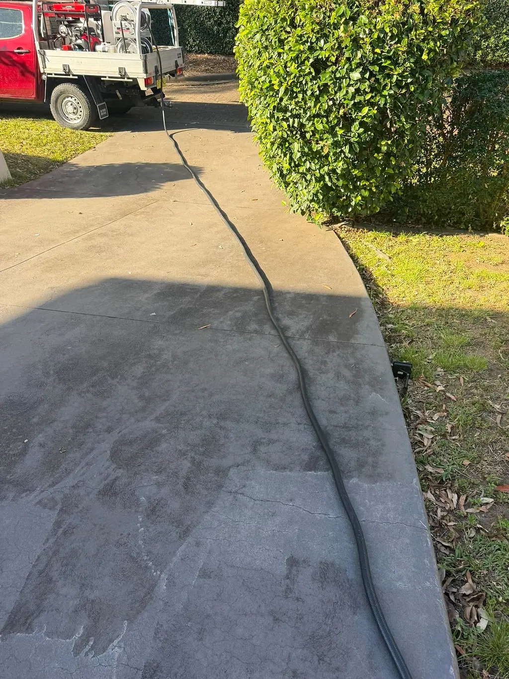 Driveway pressure cleaning by Urban Wash Sydney, clean and dirty concrete side by side